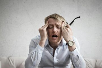 photo of man touching his head