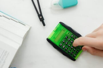 person using a small green and black calculator