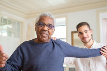 young man helping older man with physical activity