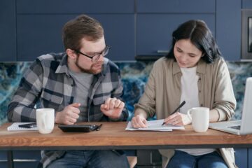 man and woman sitting at table discussing life insurance and taxes