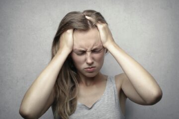 woman with a headache over figuring out health insurance